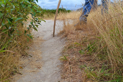 A short portion of trail narrows with a steep grade and cross slope – loose sand and grass